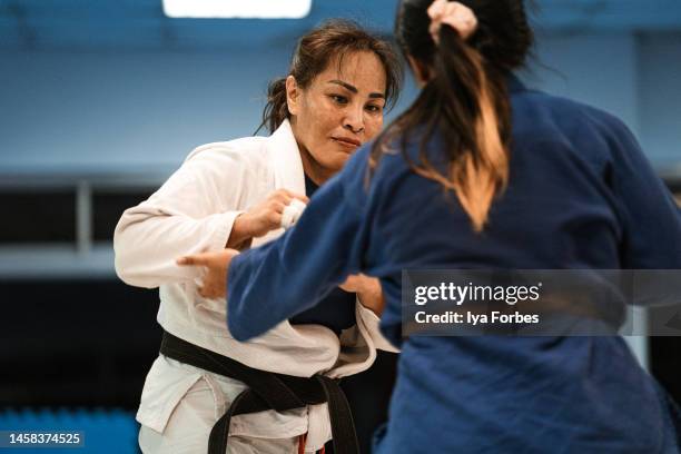 filipino woman martial artist training judo student at dojo - women judo stock pictures, royalty-free photos & images