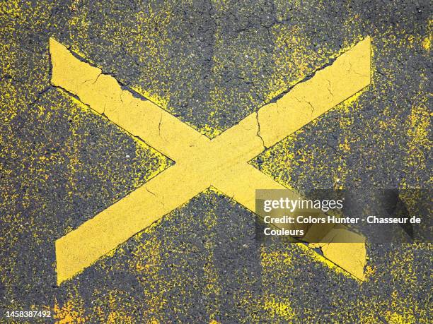 letter x painted and weathered in yellow on the gray asphalt of a street in paris - coloured tarmac stock pictures, royalty-free photos & images