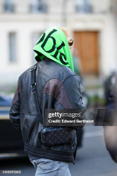 Guest wears a black and neon green print pattern wool fringed scarf, a black bomber coat, a black and white striped print pattern wool pullover, blue...