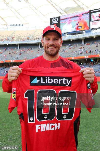 Aaron Finch of the Renegades poses with a commemorative top to mark his 100th game during the Men's Big Bash League match between the Perth Scorchers...