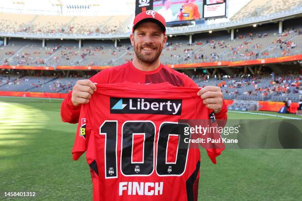 Aaron Finch of the Renegades poses with a commemorative top to mark his 100th game during the Men's Big Bash League match between the Perth Scorchers...