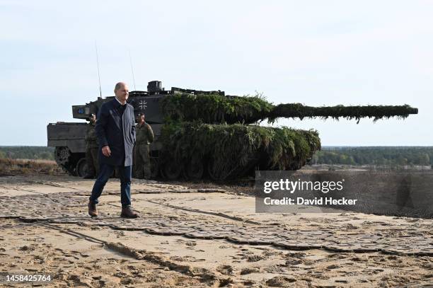 German Chancellor Olaf Scholz walks past a Leopard 2 main battle tank of the Bundeswehr while visiting the Bundeswehr army training center in...