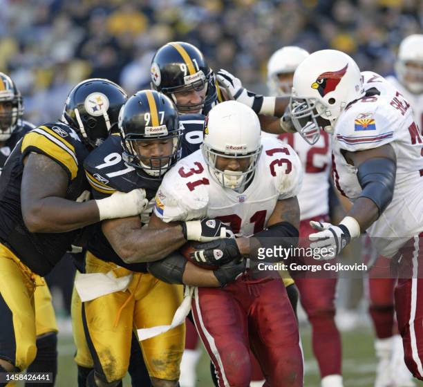 Linebacker Kendrell Bell of the Pittsburgh Steelers tackles running back Marcel Shipp of the Arizona Cardinals as defensive linemen Rodney Bailey and...