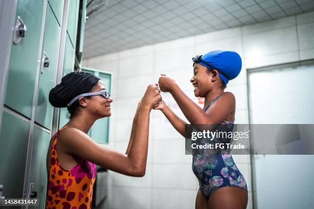 girls doing a high five in the swimming club locker room - child fist bump stock pictures, royalty-free photos & images