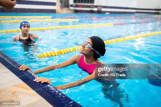 niña escuchando a su maestra en la piscina - torneo de natación fotografías e imágenes de stock