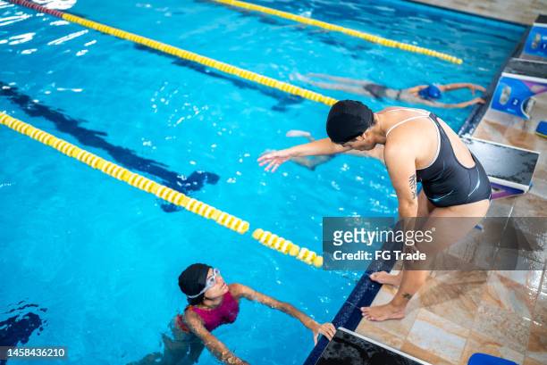 teacher in a swimming class in the pool - swim coach stock pictures, royalty-free photos & images