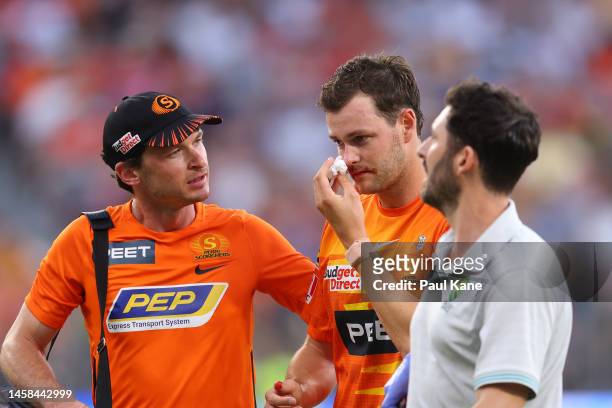 Matt Kelly of the Scorchers is assisted from the field after being hit in the face with the ball during the Men's Big Bash League match between the...