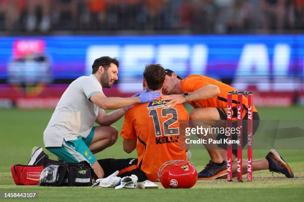 Matt Kelly of the Scorchers is attended to by medical staff after being hit in the face with the ball during the Men's Big Bash League match between...