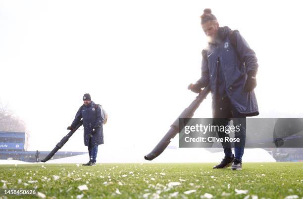 Ground staff members prepare the pitch after the covers are removed prior to the FA Women's Super League match between Chelsea and Liverpool at...