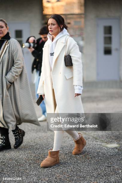 Guest wears a white hoodie sweater, a white latte wool long coat, a brown LV monogram print pattern in coated canvas shoulder bag from Louis V, white...