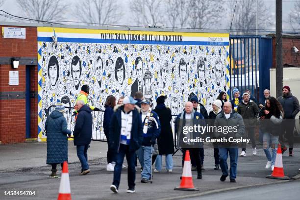 Fans of Leeds United walk pas a mural, which reads 'We've Been Through It All Together', on the outside of the stadium prior to the Premier League...