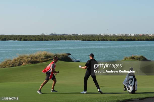 Victor Perez of France and his caddie James Erkenbeck celebrate after a birdie on the seventeenth hole during the final round of the Abu Dhabi HSBC...