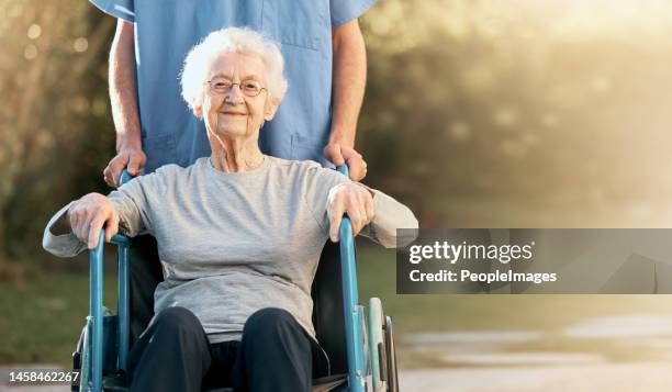 Healthcare, portrait and old woman in wheelchair with nurse in nature for wellness. Outdoors, disability and retired female with medical worker for healthy sunshine or enjoying time at park or garden