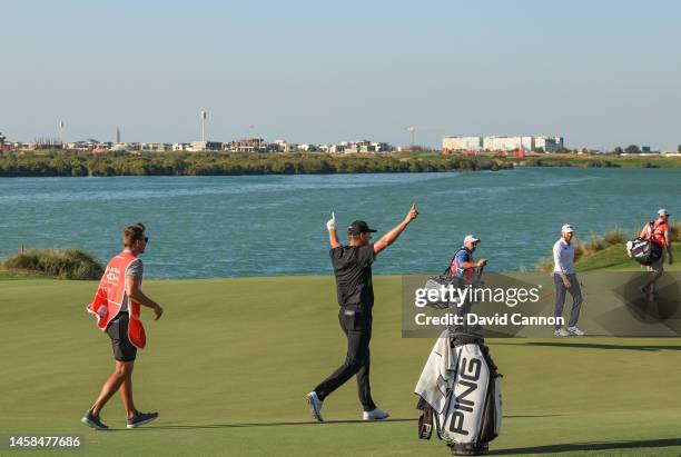 Victor Perez of France celebrates with his caddie James Erkenbeck after he had holed his second shot from the green-side bunker for a birdie 2 during...