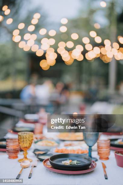 asian fusion food outdoor dining dinner table place setting - party lights stockfoto's en -beelden