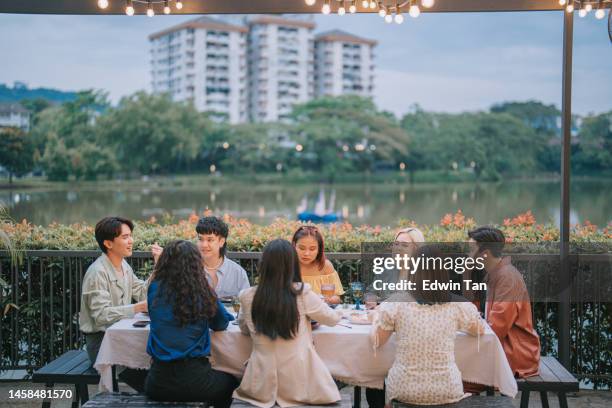 asian chinese friends enjoying outdoor dining together - waterfront dining stock pictures, royalty-free photos & images