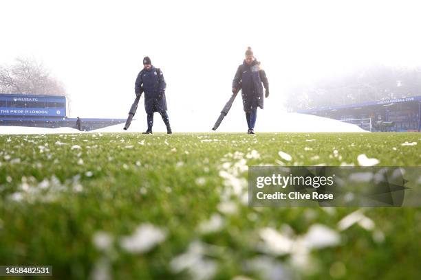 Ground staff members prepare the pitch after the covers are removed prior to the FA Women's Super League match between Chelsea and Liverpool at...