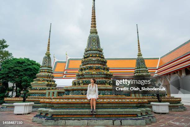 woman sitting near pagoda in   wat pho temple in bangkok - gapyear imagens e fotografias de stock