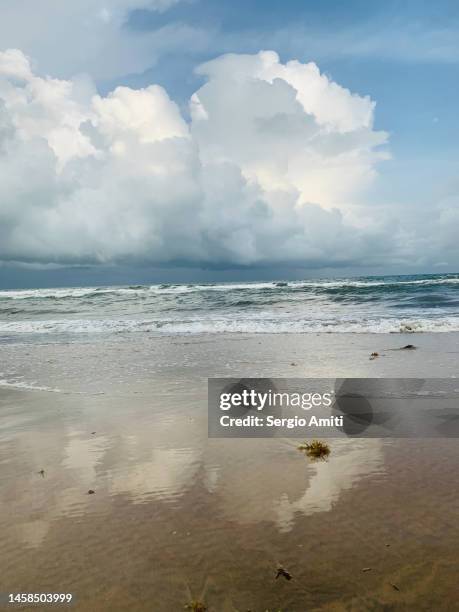 clouds reflected on water’s edge - banjul nature stock-fotos und bilder