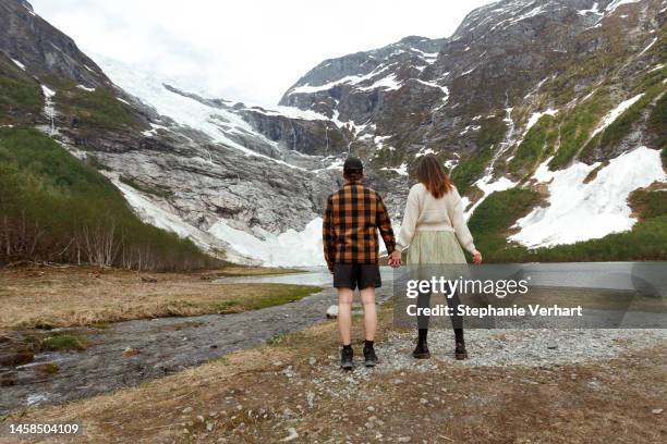 händchenhaltendes paar beim blick auf den gletscher - gletsjer stock-fotos und bilder