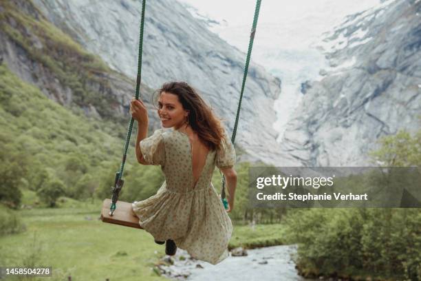 frau schwingt sich in die natur - schaukel frau stock-fotos und bilder
