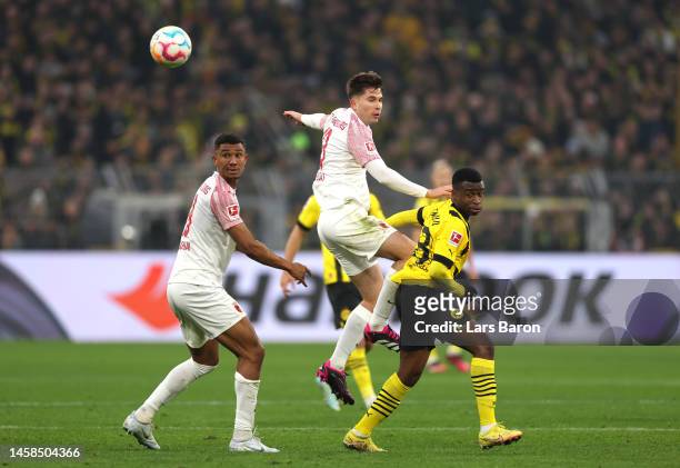 Elvis Rexhbecaj of FC Augsburg contends for the aerial ball with Youssoufa Moukoko of Borussia Dortmund during the Bundesliga match between Borussia...