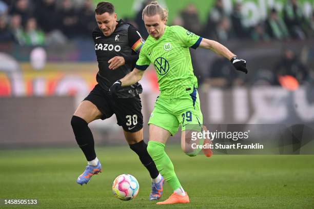 Patrick Wimmer of Wolfsburg is challenged by Christian Günter of Freiburg on the way to scoring his team's first goal during the Bundesliga match...