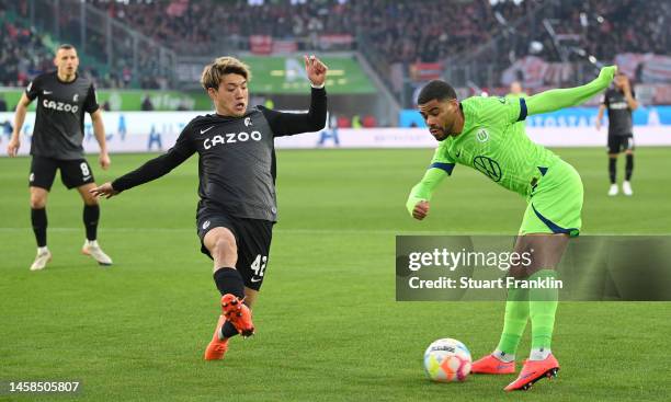 Paulo Otávio of Wolfsburg is challenged by Ritsu Doan of Freiburg during the Bundesliga match between VfL Wolfsburg and Sport-Club Freiburg at...