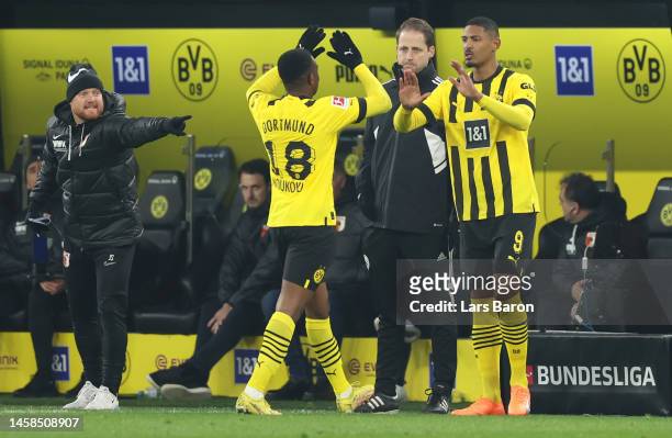 Youssoufa Moukoko is replaced by substitute Sebastien Haller of Borussia Dortmund, wearing Puma boots with the inscription 'F*ck Cancer', during the...