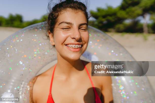 smiling young teenager at the beach - braces imagens e fotografias de stock