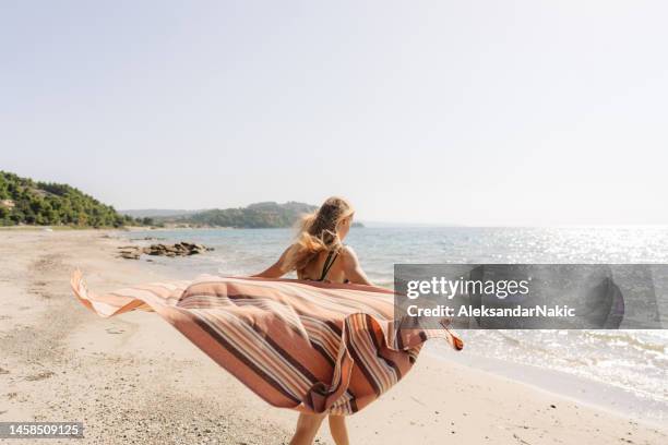 genießen sie den sommer - girl blowing sand stock-fotos und bilder