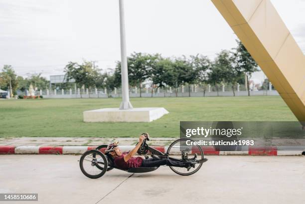 happy asian disable man is riding hand bike. - disabled extreme sports stock pictures, royalty-free photos & images