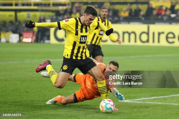 Giovanni Reyna of Borussia Dortmund breaks through on goal and is challenged by Rafal Gikiewicz of FC Augsburg during the Bundesliga match between...