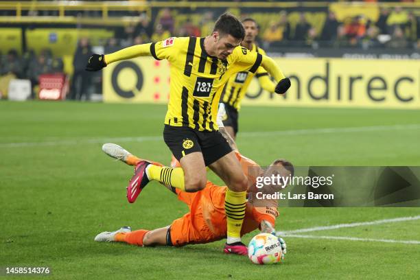 Giovanni Reyna of Borussia Dortmund breaks through on goal and is challenged by Rafal Gikiewicz of FC Augsburg during the Bundesliga match between...