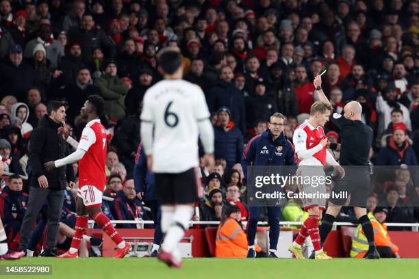 Referee Anthony Taylor shows a yellow card to Mikel Arteta, Manager of Arsenal, during the Premier League match between Arsenal FC and Manchester...