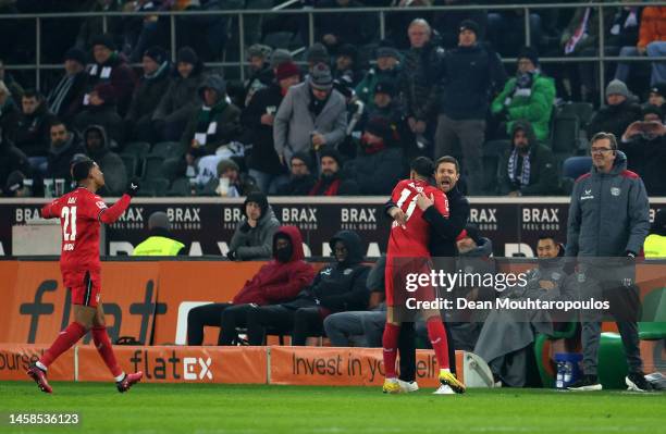 Nadiem Amiri of Bayer 04 Leverkusen celebrates with Xabi Alonso, Head Coach of Bayer 04 Leverkusen, after scoring the team's third goal during the...