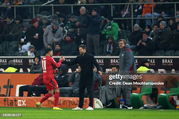 Nadiem Amiri of Bayer 04 Leverkusen celebrates with Xabi Alonso, Head Coach of Bayer 04 Leverkusen, after scoring the team's third goal during the...