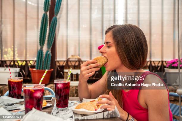 young blonde girl with long hair eating tacos and drinking wine on the terrace of a restaurant. - tortilla stock-fotos und bilder