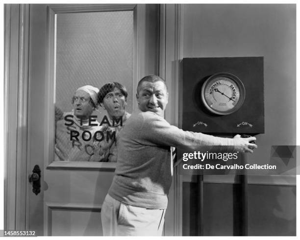 The Three Stooges consisting of Larry Fine , Moe Howard and Curly Howard in the steam room scene from the film 'Monkey Businessmen' United States.