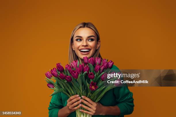 beautiful emotional woman holding bouquet of flowers - holding flowers stock pictures, royalty-free photos & images