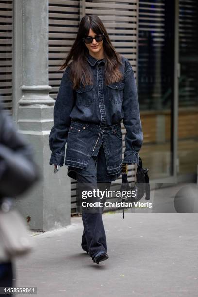 Leia Sfez wears dark denim jeans jacket, jeans, black bag wears outside Sacai during Paris Fashion Week - Menswear Fall-Winter 2023-2024 on January...