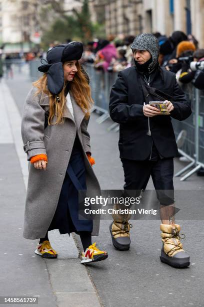 Guest wears hat, grey coatoutside Sacai during Paris Fashion Week - Menswear Fall-Winter 2023-2024 on January 22, 2023 in Paris, France.