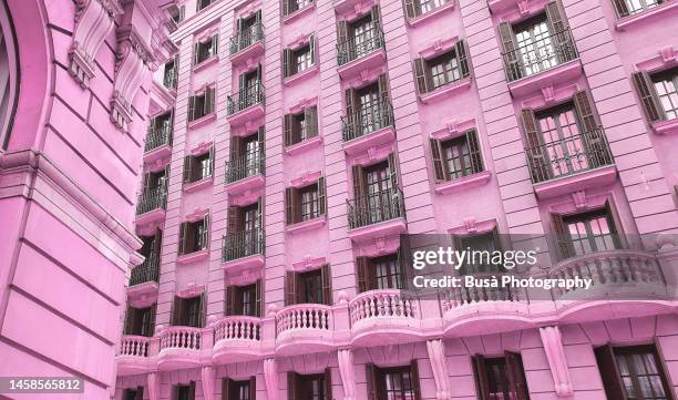 ornate historic buildings with pink hue (color correction) - stories of the day stock-fotos und bilder