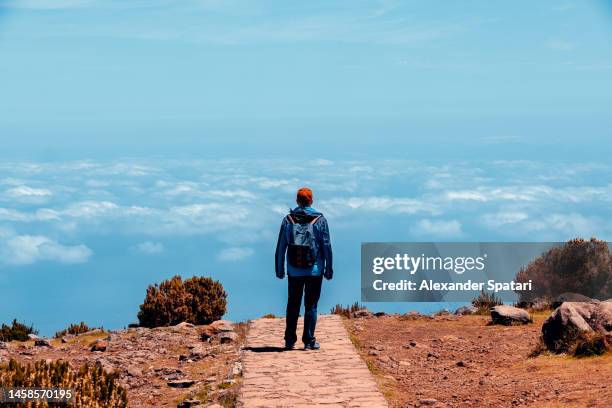 man on a hiking trail above clouds on madeira island, portugal - pico ruivo stock pictures, royalty-free photos & images