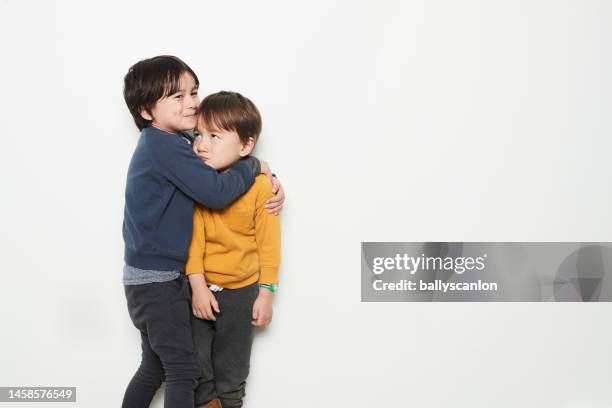 studio shot of a multiracial boy and his brother. - friends studio shot stock pictures, royalty-free photos & images