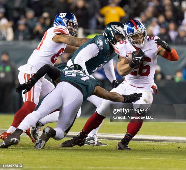 New York Giants running back Saquon Barkley is tackled by Philadelphia Eagles linebacker T.J. Edwards during the NFC divisional playoff game between...