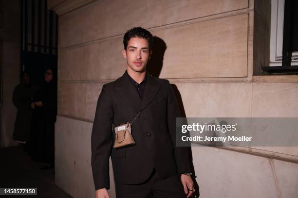 Manu Rios is seen wearing a black suit and a mini brown handbag outside Maison Margiela Show, during the Paris Fashion Week - Menswear Fall Winter...