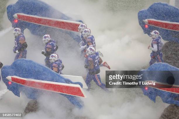 The Buffalo Bills take the field as snow falls in the AFC Divisional Playoff game against the Cincinnati Bengals at Highmark Stadium on January 22,...