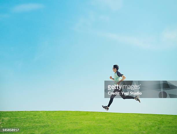 man running on lawn - jogging stock pictures, royalty-free photos & images