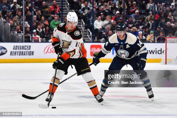 Trevor Zegras of the Anaheim Ducks skates with the puck as Gustav Nyquist of the Columbus Blue Jackets defends during the third period of a game at...